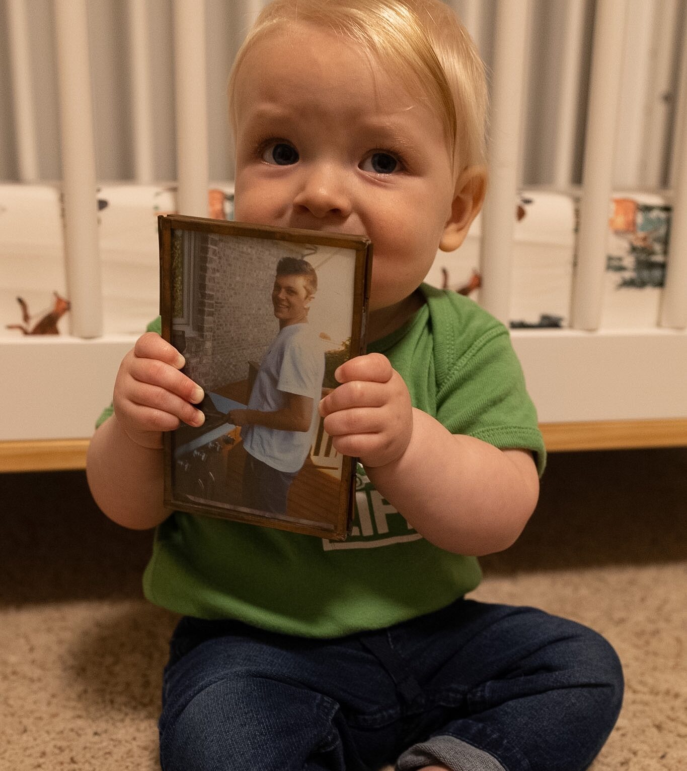 A baby holding a picture frame of Ben
